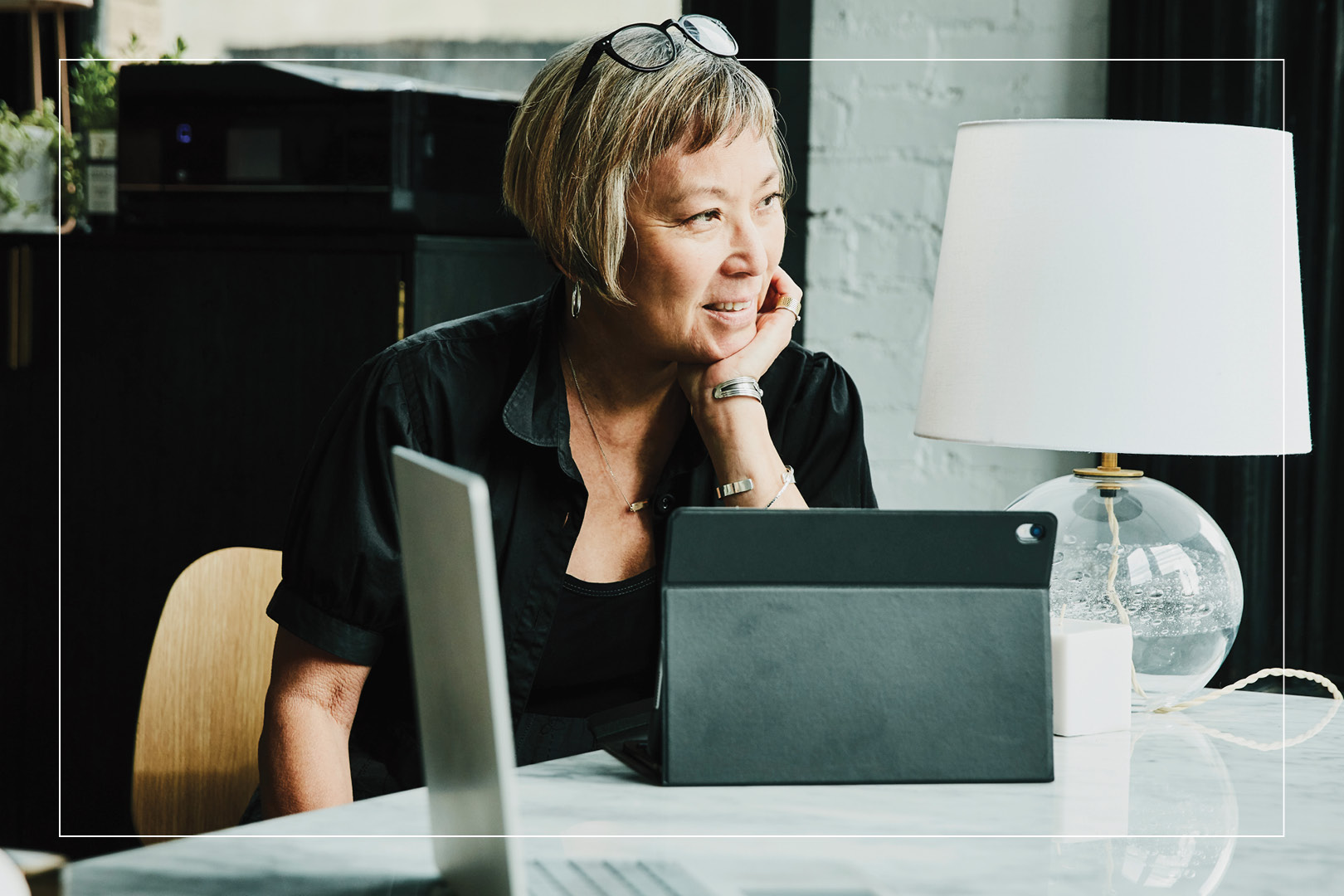 older woman sitting at table with tablet