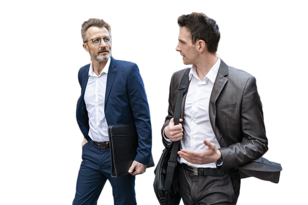 Two businessmen walking and talking at an old brick building